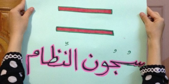 Suad holding one of her signs against ISIS