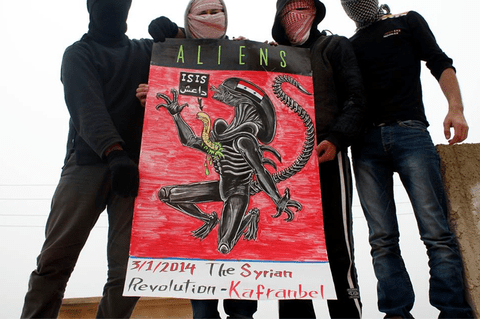 حاز الناشطون في كفرنبل على قدر من الاهتمام الدولي من خلال لافتاتهم وملصقاتهم الإبداعية. في مظاهرة حديثة، حمل المتظاهرون لافتة تقارن الجماعة المتمردة المرتبطة بالقاعدة بالوحش في فيلم الغرباء.