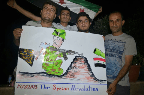 لافتة استخدمت في احتجاج الصيف الماضي تصور جنديا من الجيش السوري الحر المدعوم من الغرب يتعرض للطعن في الظهر على يد أحد أفراد داعش المرتبطة بالقاعدة.