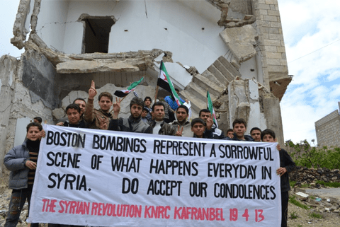 نشطاء في بلدة كفرنبل السورية يرفعون لافتة تقارن بين تفجير ماراثون بوسطن وأعمال العنف اليومية في سوريا. قال رائد فارس، مدير المركز الإعلامي في كفرنبل، إنه يعتقد أنه من المهم الربط بين المعاناة في سوريا والمآسي في أماكن أخرى من العالم.